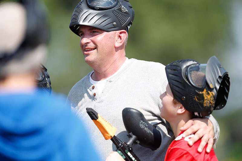 Loving embrace between father and son while playing paintball at Cousins Paintball